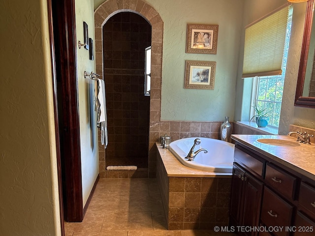 1216 N Oak Grove Rd, Drumright, OK 74030 - full bathroom with a textured wall, a garden tub, walk in shower, vanity, and tile patterned floors
