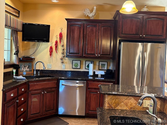 1216 N Oak Grove Rd, Drumright, OK 74030 - kitchen with stainless steel appliances, a sink, dark stone counters, and a textured wall