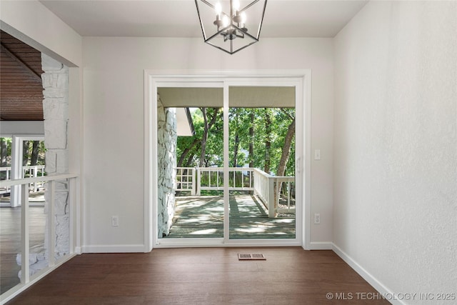 3442 E 75th Pl, Tulsa, OK 74136 - doorway with a chandelier, baseboards, and wood finished floors