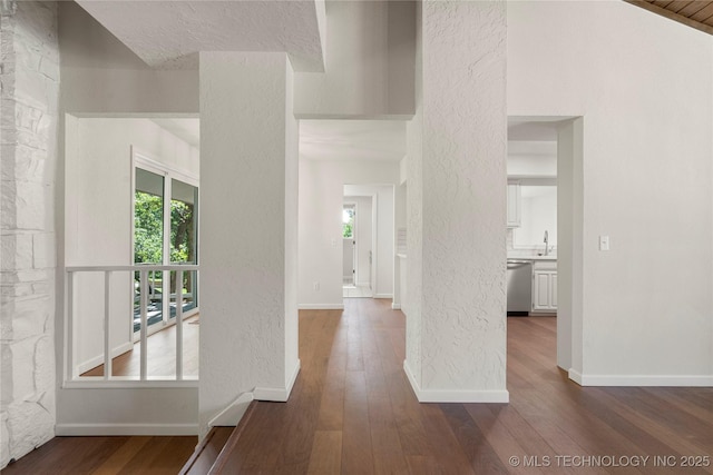 3442 E 75th Pl, Tulsa, OK 74136 - hall with dark wood finished floors, baseboards, a textured wall, and a sink