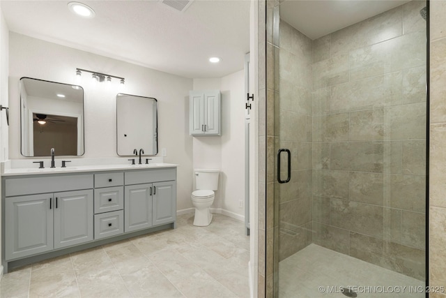 3442 E 75th Pl, Tulsa, OK 74136 - bathroom featuring a stall shower, toilet, ceiling fan, double vanity, and recessed lighting
