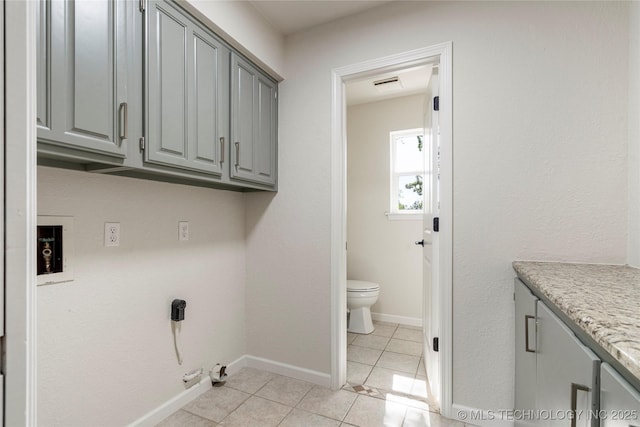 3442 E 75th Pl, Tulsa, OK 74136 - laundry area with cabinet space, gas dryer hookup, light tile patterned floors, hookup for a washing machine, and baseboards