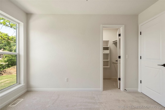 3442 E 75th Pl, Tulsa, OK 74136 - unfurnished bedroom featuring a walk in closet, carpet flooring, baseboards, and a closet