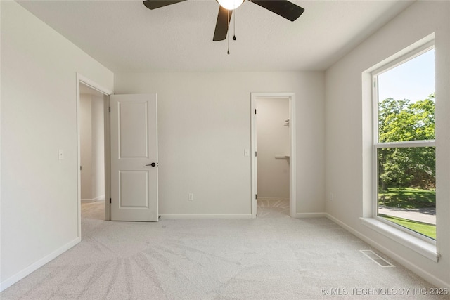3442 E 75th Pl, Tulsa, OK 74136 - unfurnished bedroom with multiple windows, carpet, and a walk in closet