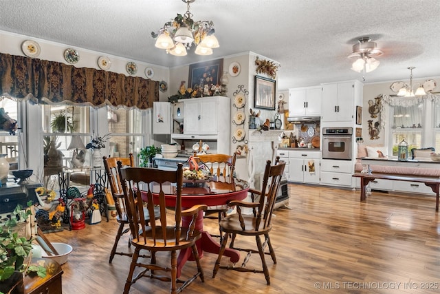 819 W Elm St, Durant, OK 74701 - dining area featuring a chandelier, a textured ceiling, light wood-style flooring, and crown molding