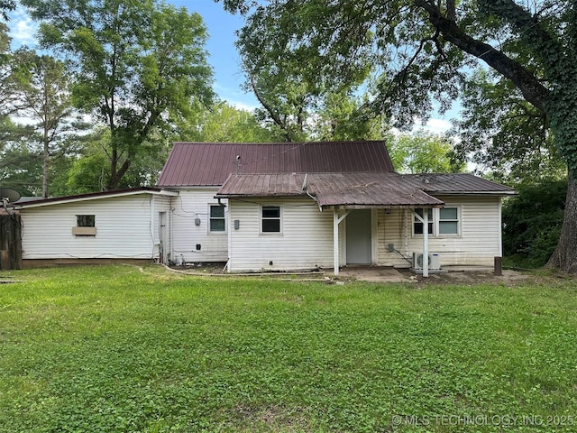 709 W Durant, Wilburton, OK 74578 - rear view of house featuring a lawn and metal roof