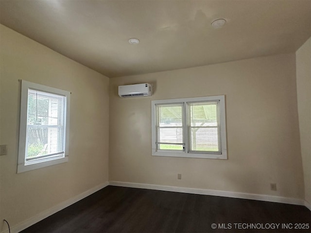 709 W Durant, Wilburton, OK 74578 - unfurnished room with a wall unit AC, healthy amount of natural light, dark wood finished floors, and baseboards