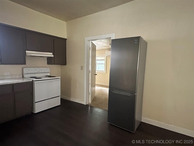 709 W Durant, Wilburton, OK 74578 - kitchen with white range with electric stovetop, freestanding refrigerator, light countertops, under cabinet range hood, and baseboards