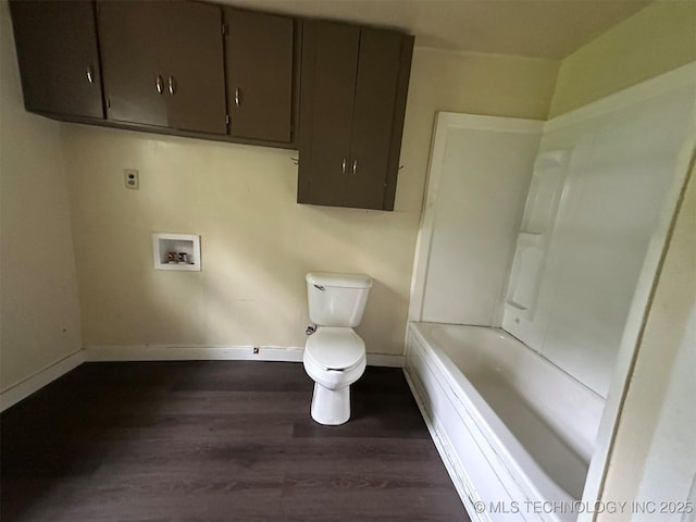 709 W Durant, Wilburton, OK 74578 - bathroom featuring wood finished floors, baseboards, toilet, and a tub