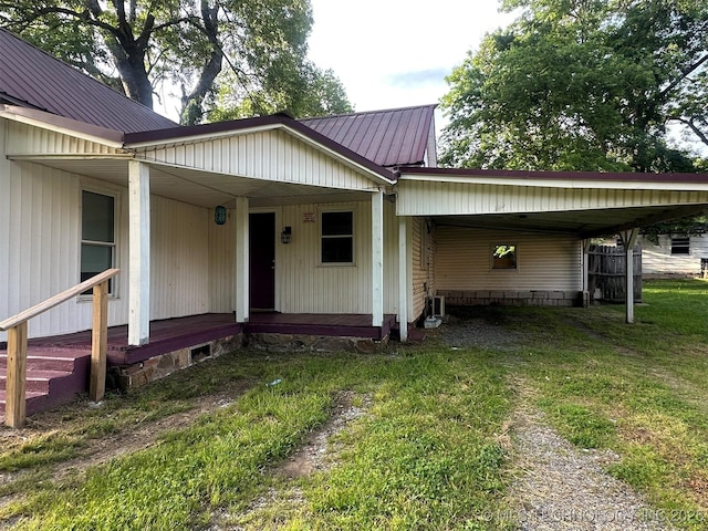 709 W Durant, Wilburton, OK 74578 - view of front of property featuring an attached carport, a front yard, and metal roof
