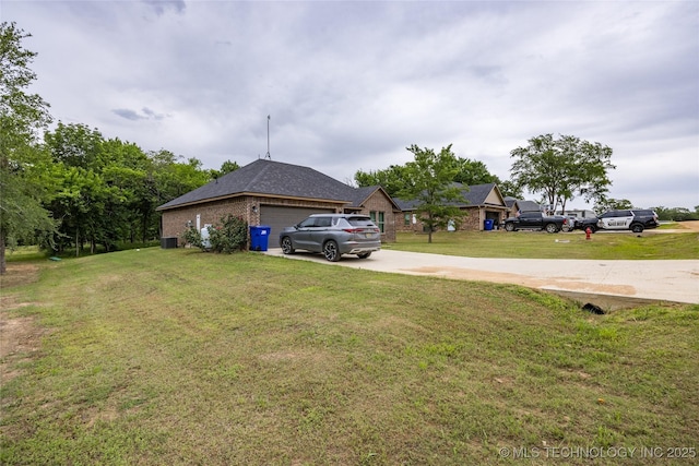 71 Rebel Ln, Durant, OK 74701 - view of grassy yard featuring driveway, a garage, and central air condition unit