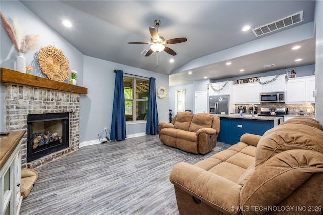 71 Rebel Ln, Durant, OK 74701 - living area with a ceiling fan, a brick fireplace, recessed lighting, vaulted ceiling, and baseboards