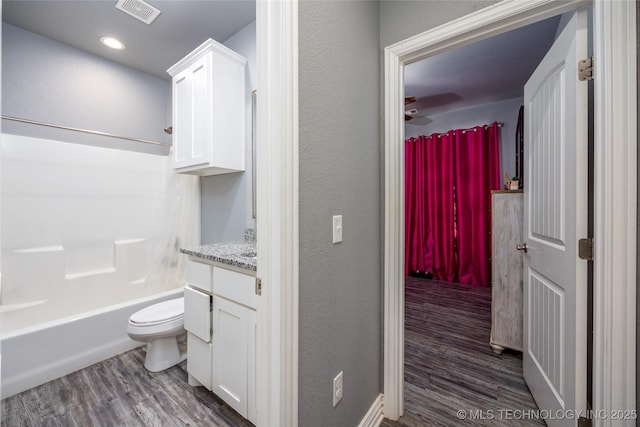 71 Rebel Ln, Durant, OK 74701 - full bath with wood finished floors, toilet, vanity, shower / bathtub combination, and a textured wall