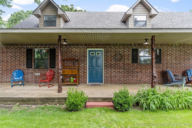 10797 S Talala Creek Ct # B, Talala, OK 74080 - property entrance with brick siding, roof with shingles, a porch, and a patio area