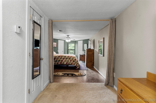10797 S Talala Creek Ct # B, Talala, OK 74080 - carpeted bedroom with a textured wall, a textured ceiling, ceiling fan, and wood finished floors