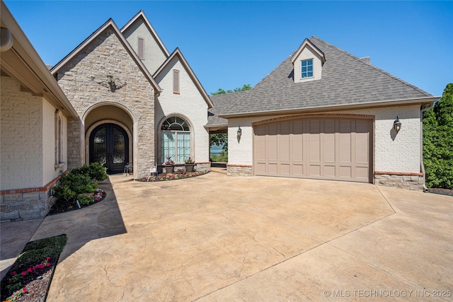 12432 Boulder Rdg, Sperry, OK 74073 - french country inspired facade with french doors, driveway, a garage, a shingled roof, and stone siding