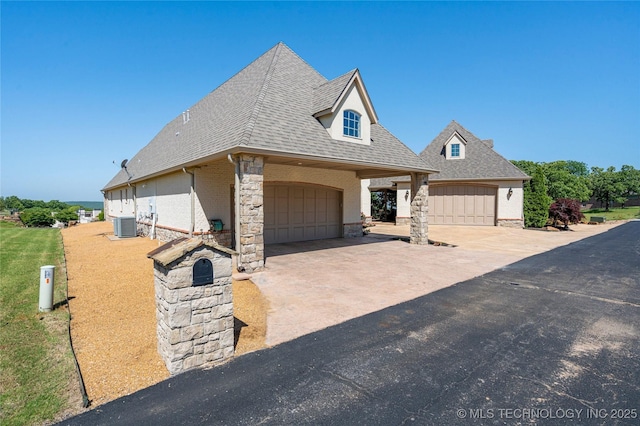 12432 Boulder Rdg, Sperry, OK 74073 - view of front of property featuring roof with shingles, a garage, central air condition unit, and brick siding