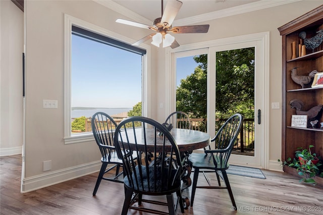 12432 Boulder Rdg, Sperry, OK 74073 - dining space with wood finished floors, ornamental molding, ceiling fan, baseboards, and a water view