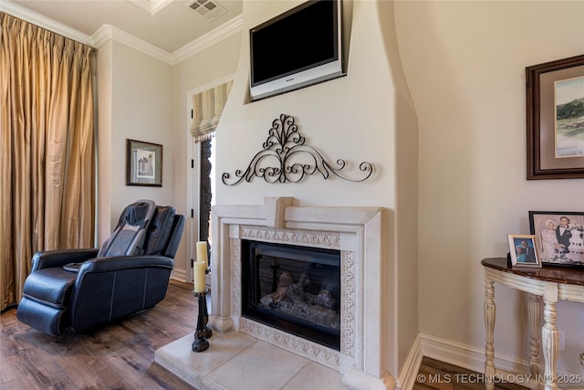 12432 Boulder Rdg, Sperry, OK 74073 - sitting room with wood finished floors, crown molding, a glass covered fireplace, and baseboards