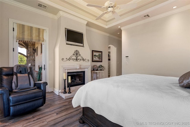 12432 Boulder Rdg, Sperry, OK 74073 - bedroom featuring arched walkways, dark wood-style flooring, ornamental molding, a glass covered fireplace, and baseboards