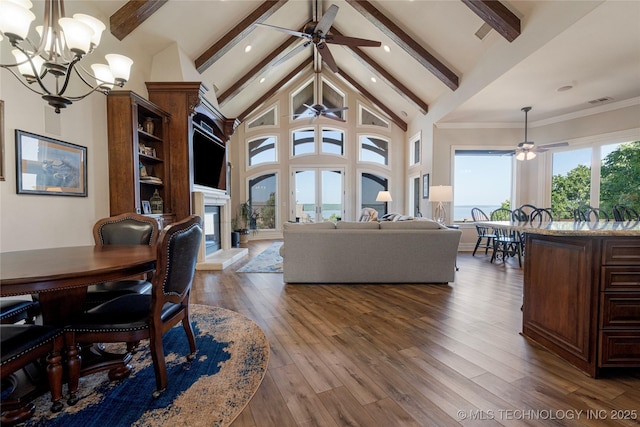 12432 Boulder Rdg, Sperry, OK 74073 - living area with a ceiling fan, beam ceiling, a glass covered fireplace, a chandelier, and wood finished floors