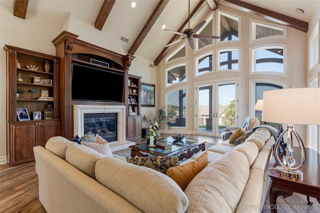12432 Boulder Rdg, Sperry, OK 74073 - living room featuring beamed ceiling, high vaulted ceiling, light wood-style flooring, ceiling fan, and a glass covered fireplace