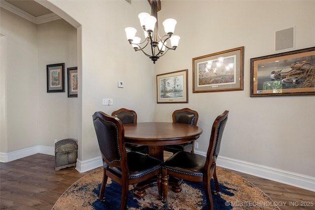 12432 Boulder Rdg, Sperry, OK 74073 - dining space with arched walkways, wood finished floors, baseboards, a chandelier, and ornamental molding