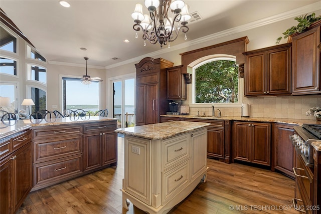 12432 Boulder Rdg, Sperry, OK 74073 - kitchen with stainless steel stove, a sink, light stone countertops, pendant lighting, and wood finished floors