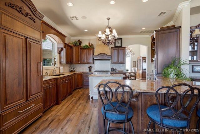 12432 Boulder Rdg, Sperry, OK 74073 - kitchen with a chandelier, a kitchen bar, recessed lighting, light stone countertops, and arched walkways