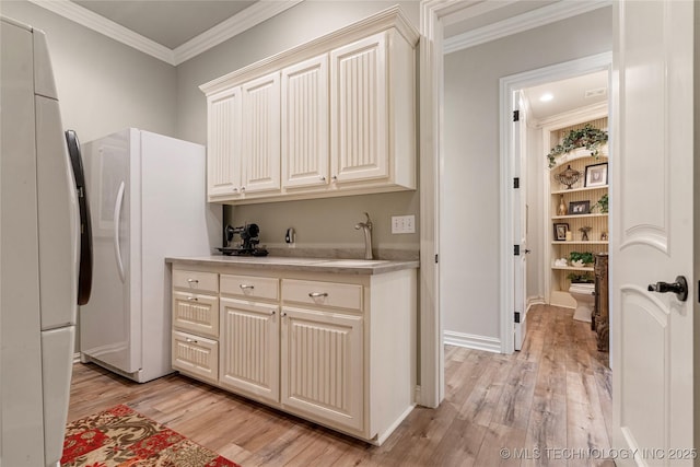 12432 Boulder Rdg, Sperry, OK 74073 - kitchen featuring a sink, light wood-type flooring, ornamental molding, light countertops, and freestanding refrigerator