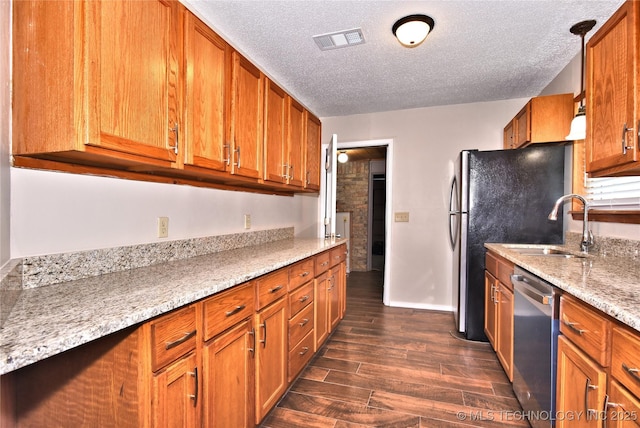 12518 E 25th St, Tulsa, OK 74129 - kitchen with stainless steel dishwasher, a textured ceiling, a sink, dark wood-style flooring, and brown cabinets