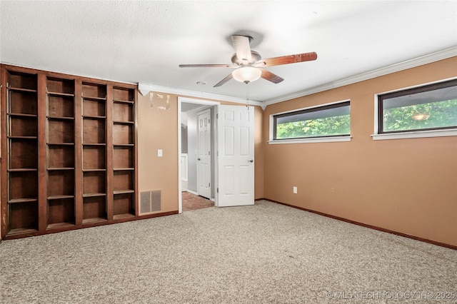 unfurnished bedroom with carpet floors, crown molding, baseboards, and a ceiling fan