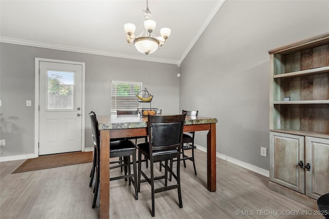 dining room featuring crown molding, a chandelier, light wood-style flooring, baseboards, and lofted ceiling