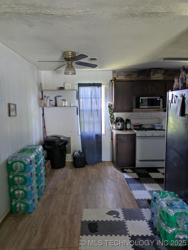 115 W Lisa Ln, Big Cabin, OK 74332 - kitchen with appliances with stainless steel finishes, tile patterned floors, a ceiling fan, a textured ceiling, and dark brown cabinetry