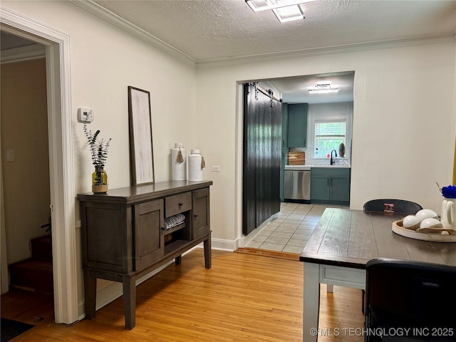 2009 S Osage Ave, Bartlesville, OK 74006 - corridor featuring a sink, light wood finished floors, ornamental molding, and a textured ceiling