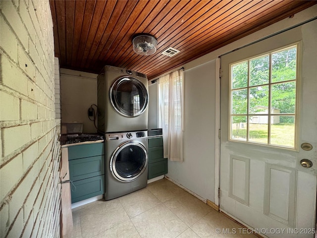 2009 S Osage Ave, Bartlesville, OK 74006 - laundry room with estacked washer and dryer, wooden ceiling, light tile patterned floors, and cabinet space