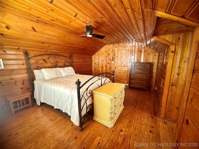 2009 S Osage Ave, Bartlesville, OK 74006 - bedroom featuring wood ceiling, wooden walls, vaulted ceiling, and hardwood / wood-style floors