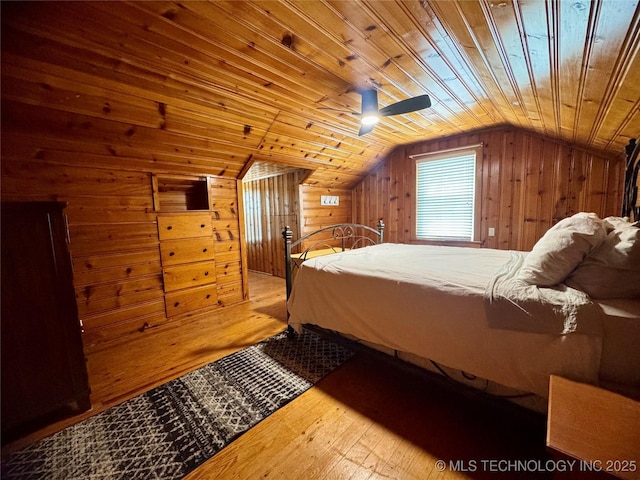 2009 S Osage Ave, Bartlesville, OK 74006 - bedroom featuring hardwood / wood-style floors, lofted ceiling, wood walls, wooden ceiling, and a ceiling fan