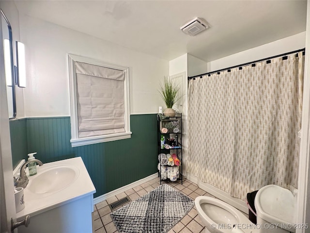 2009 S Osage Ave, Bartlesville, OK 74006 - bathroom with tile patterned flooring, wainscoting, toilet, vanity, and a shower with shower curtain