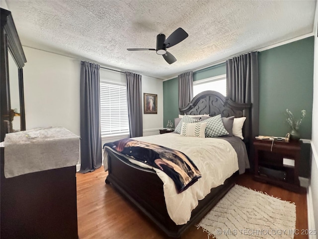 2009 S Osage Ave, Bartlesville, OK 74006 - bedroom with wood finished floors, a textured ceiling, and ceiling fan