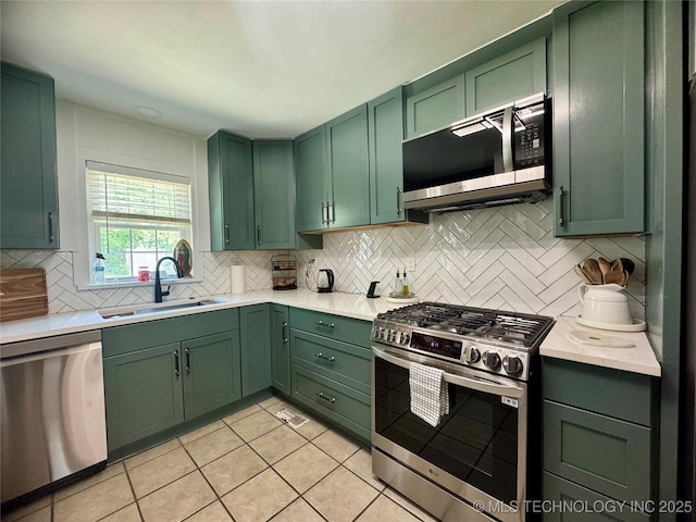 2009 S Osage Ave, Bartlesville, OK 74006 - kitchen with green cabinets, stainless steel appliances, a sink, and light countertops