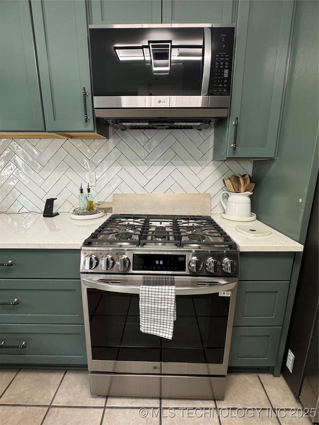 2009 S Osage Ave, Bartlesville, OK 74006 - kitchen with green cabinets, stainless steel appliances, and light tile patterned floors
