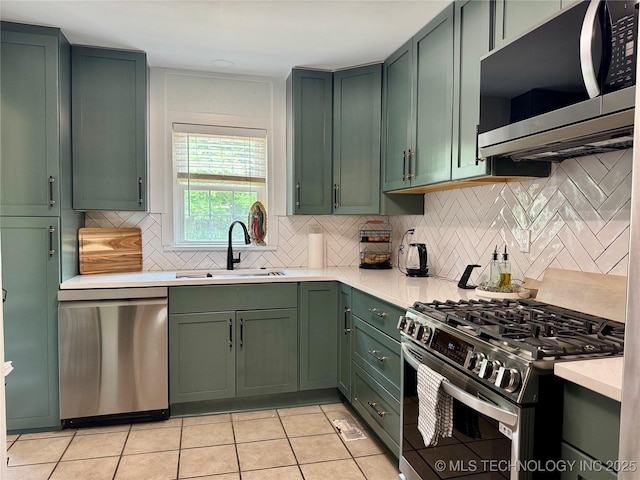 2009 S Osage Ave, Bartlesville, OK 74006 - kitchen with appliances with stainless steel finishes, green cabinets, and a sink
