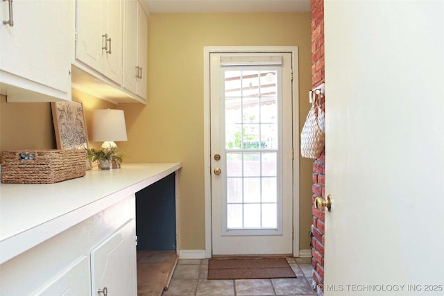 4507 S Irvington Ave, Tulsa, OK 74135 - doorway to outside featuring plenty of natural light, light tile patterned floors, and baseboards