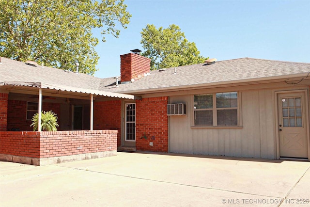 4507 S Irvington Ave, Tulsa, OK 74135 - back of property featuring a chimney, a shingled roof, a patio, brick siding, and a wall unit AC