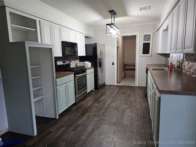 309 Hillcrest St, Pawnee, OK 74058 - kitchen featuring stainless steel appliances, backsplash, crown molding, a sink, and dark wood-style flooring