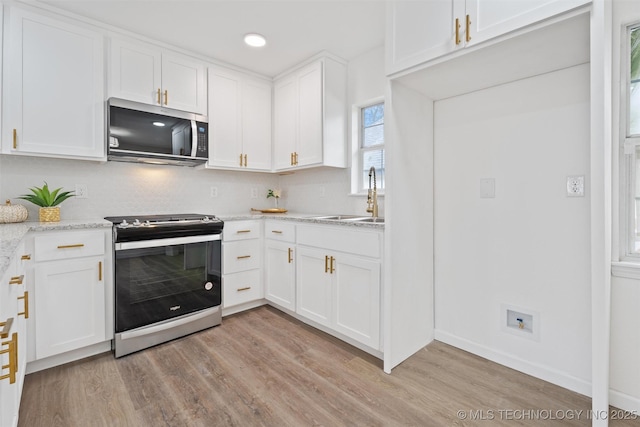 3919 E Archer St, Tulsa, OK 74115 - kitchen featuring appliances with stainless steel finishes, light wood-style floors, white cabinetry, light stone countertops, and recessed lighting