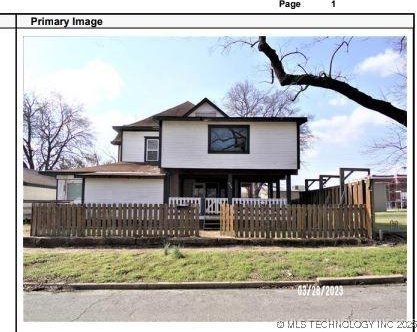 408 E 7th St, Okmulgee, OK 74447 - view of front facade with a fenced front yard