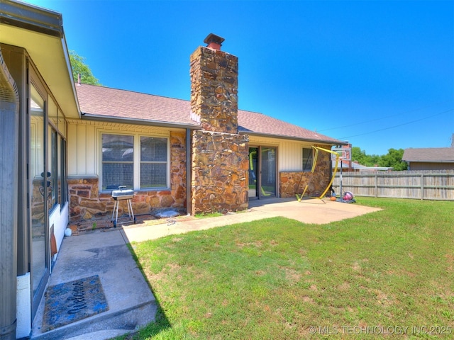 124 Canterbury Ct, Bartlesville, OK 74006 - rear view of house featuring a chimney, stone siding, a patio, and roof with shingles