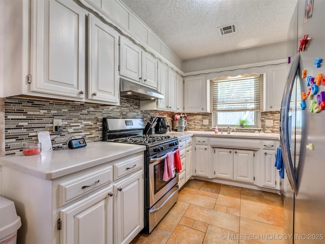 124 Canterbury Ct, Bartlesville, OK 74006 - kitchen featuring stainless steel appliances, under cabinet range hood, a textured ceiling, and white cabinetry